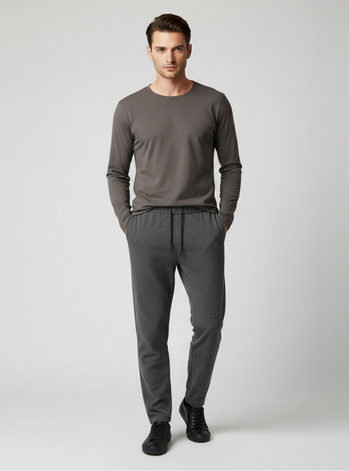 Man wearing a gray long-sleeve shirt and pants on a white background