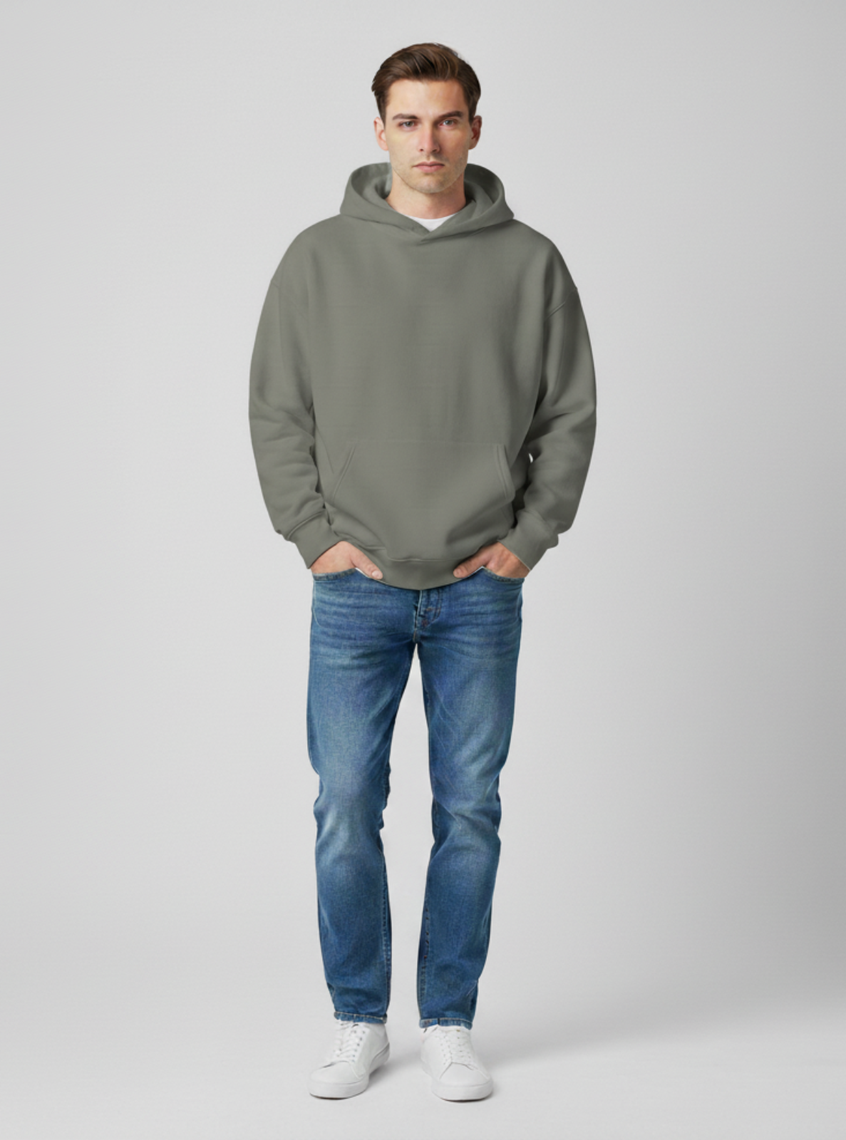 Man wearing a gray hoodie and blue jeans on a white background