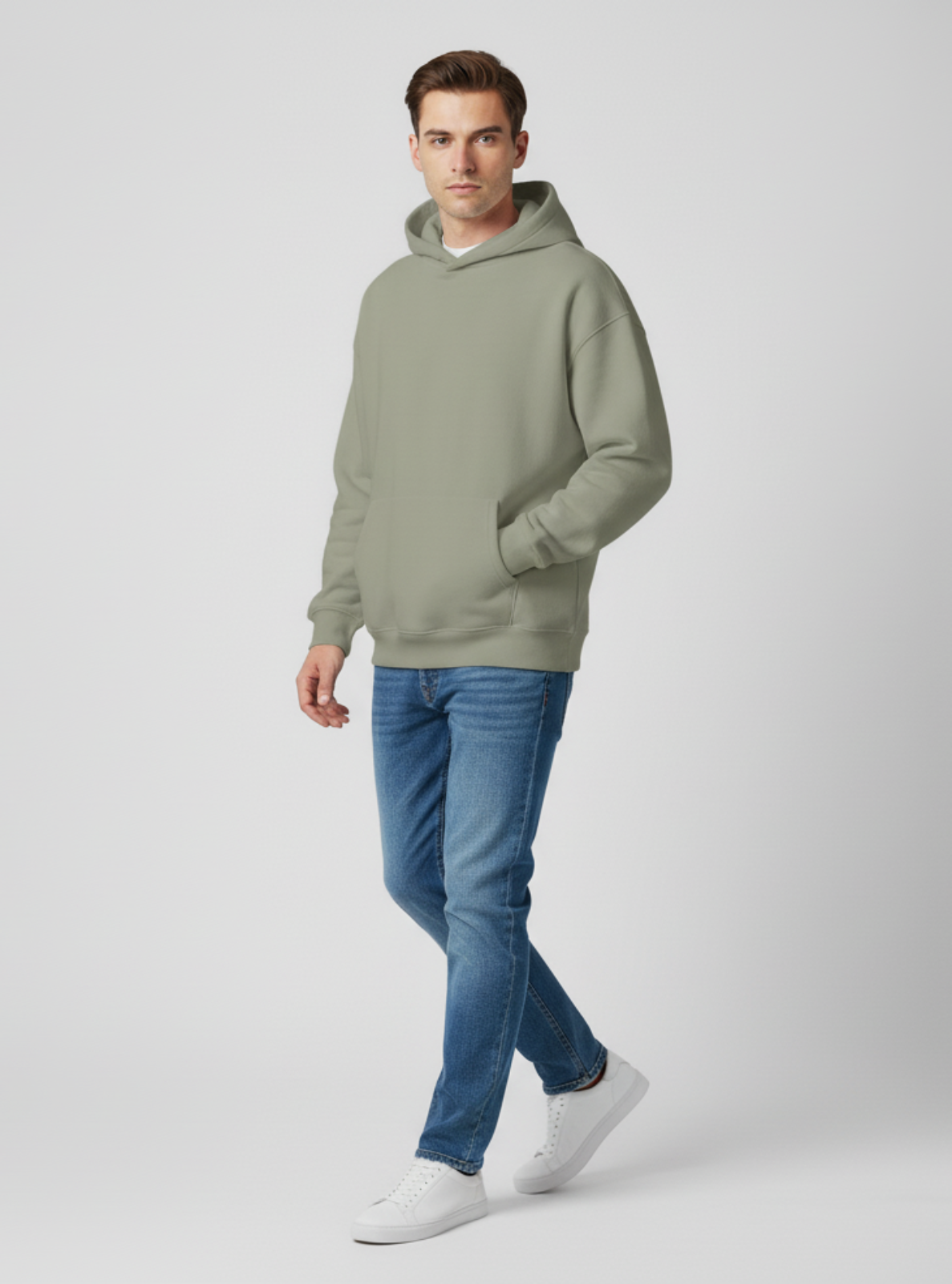 Man wearing a green hoodie and blue jeans on a white background