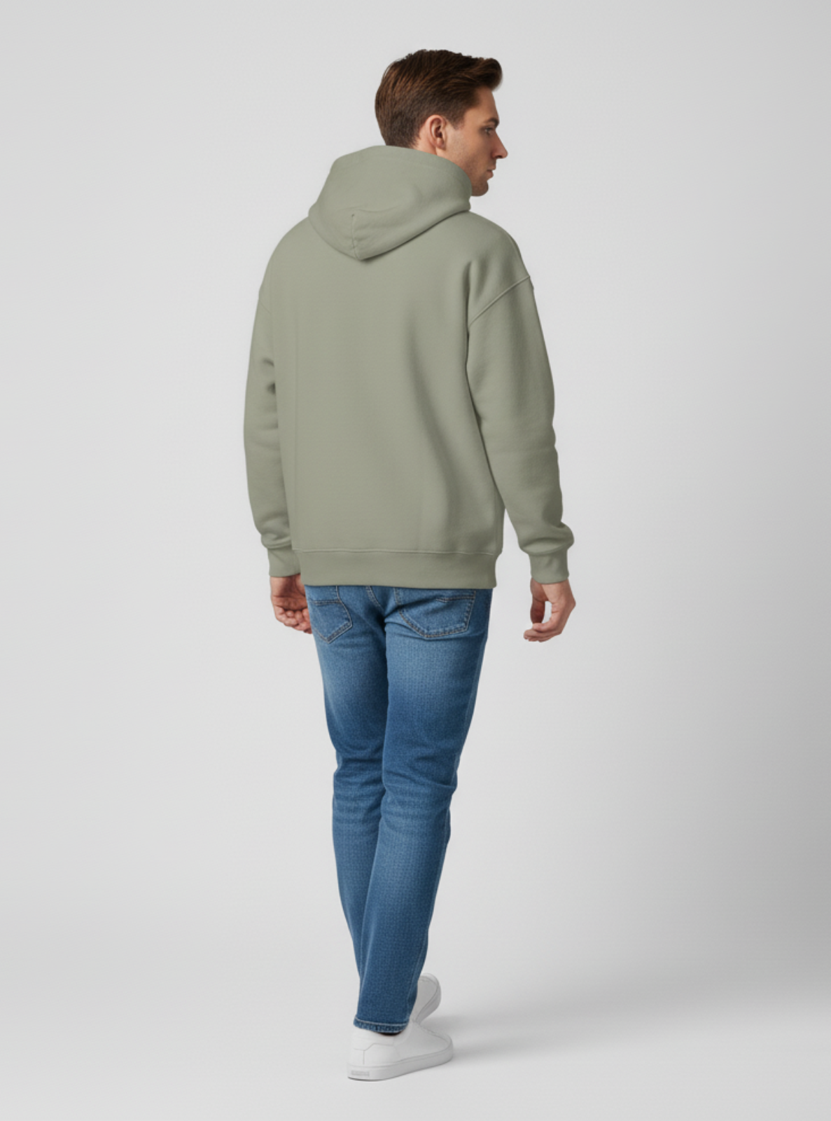 Person wearing a green hoodie and blue jeans on a white background