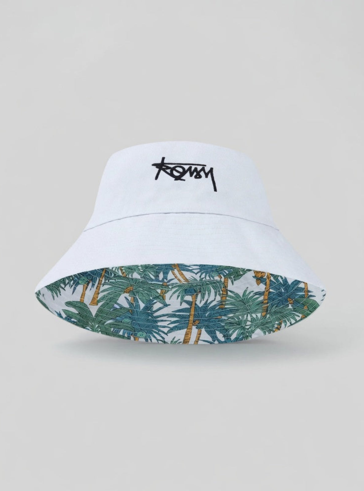 White bucket hat with tropical pattern inside on a light gray background