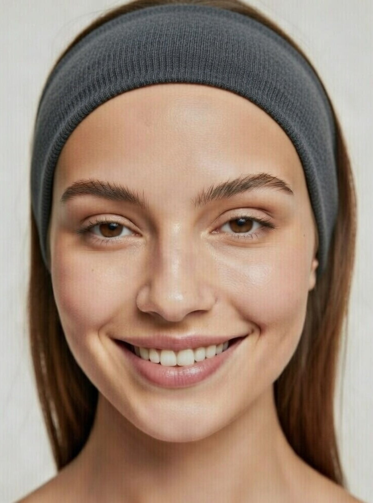 Woman wearing a gray headband against a plain background