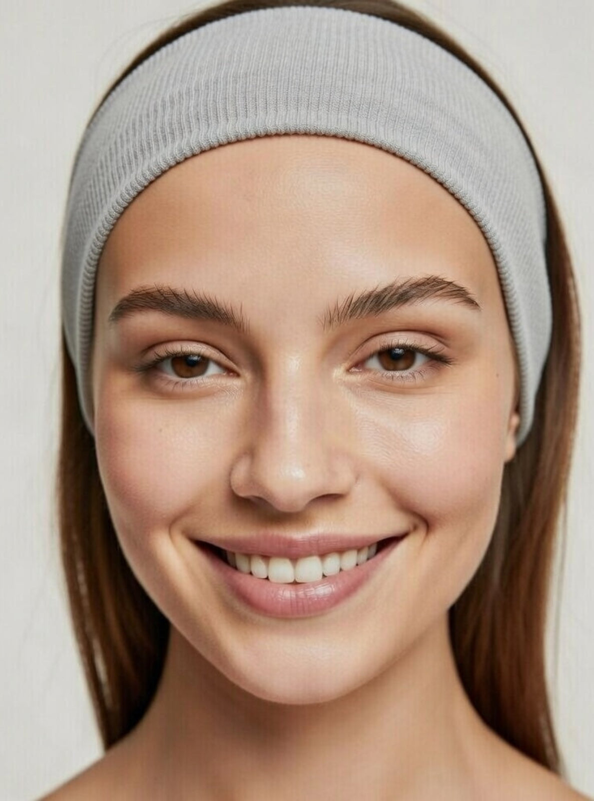 Woman wearing a gray headband against a plain background