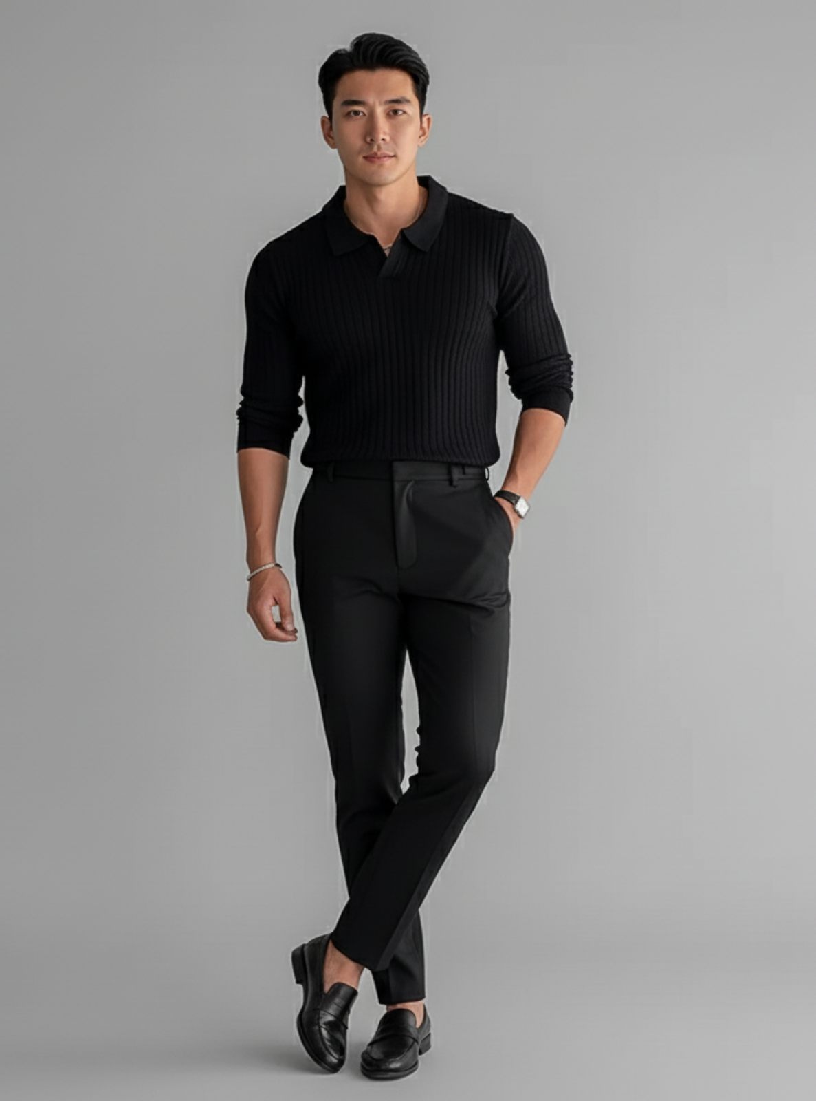 Man wearing a black outfit on a gray background