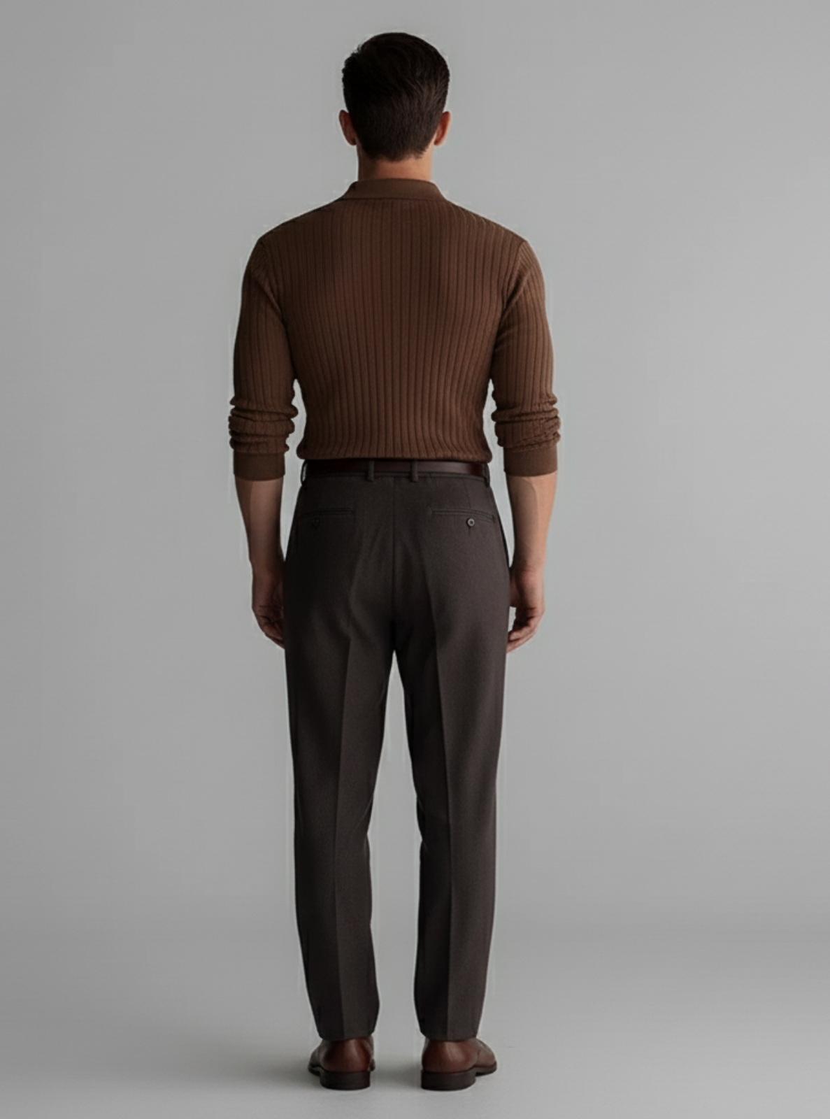 Man wearing a brown ribbed sweater and matching pants on a gray background