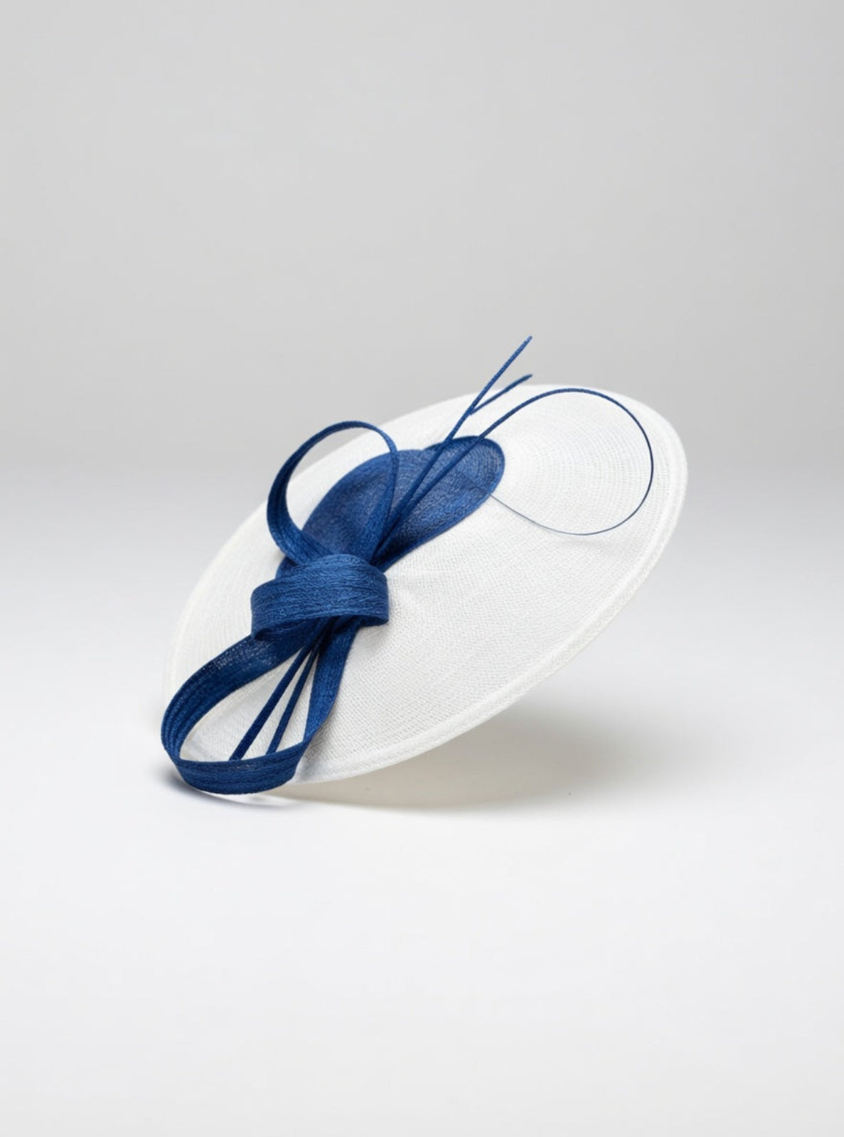 White hat with a blue bow on a light gray background