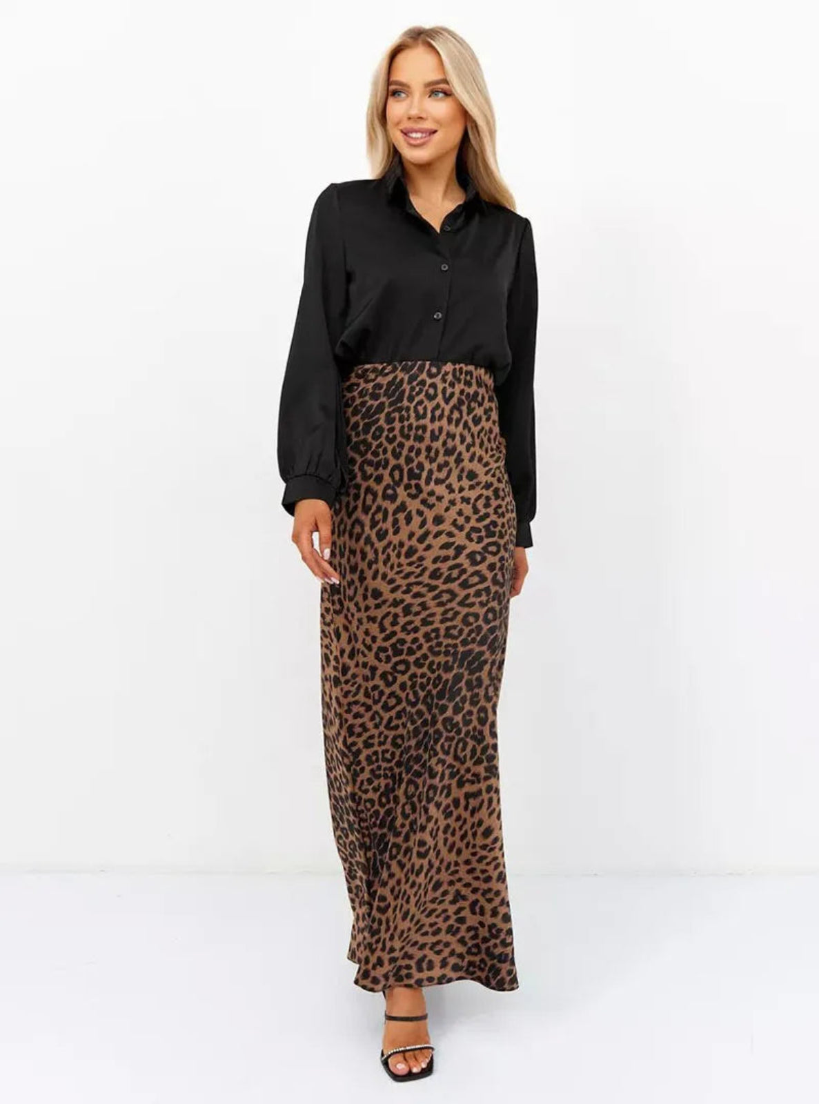 Woman wearing a black blouse and leopard print skirt on a white background