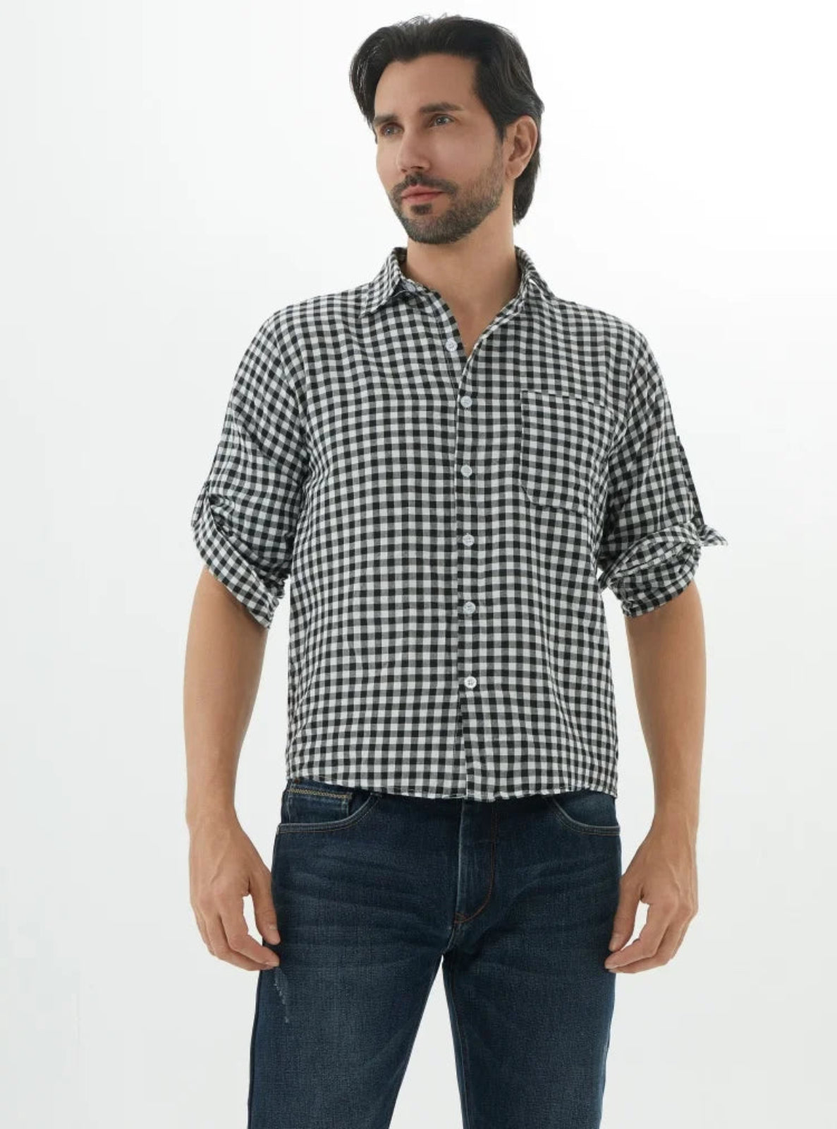 Man wearing a black and white checkered shirt with rolled-up sleeves on a white background