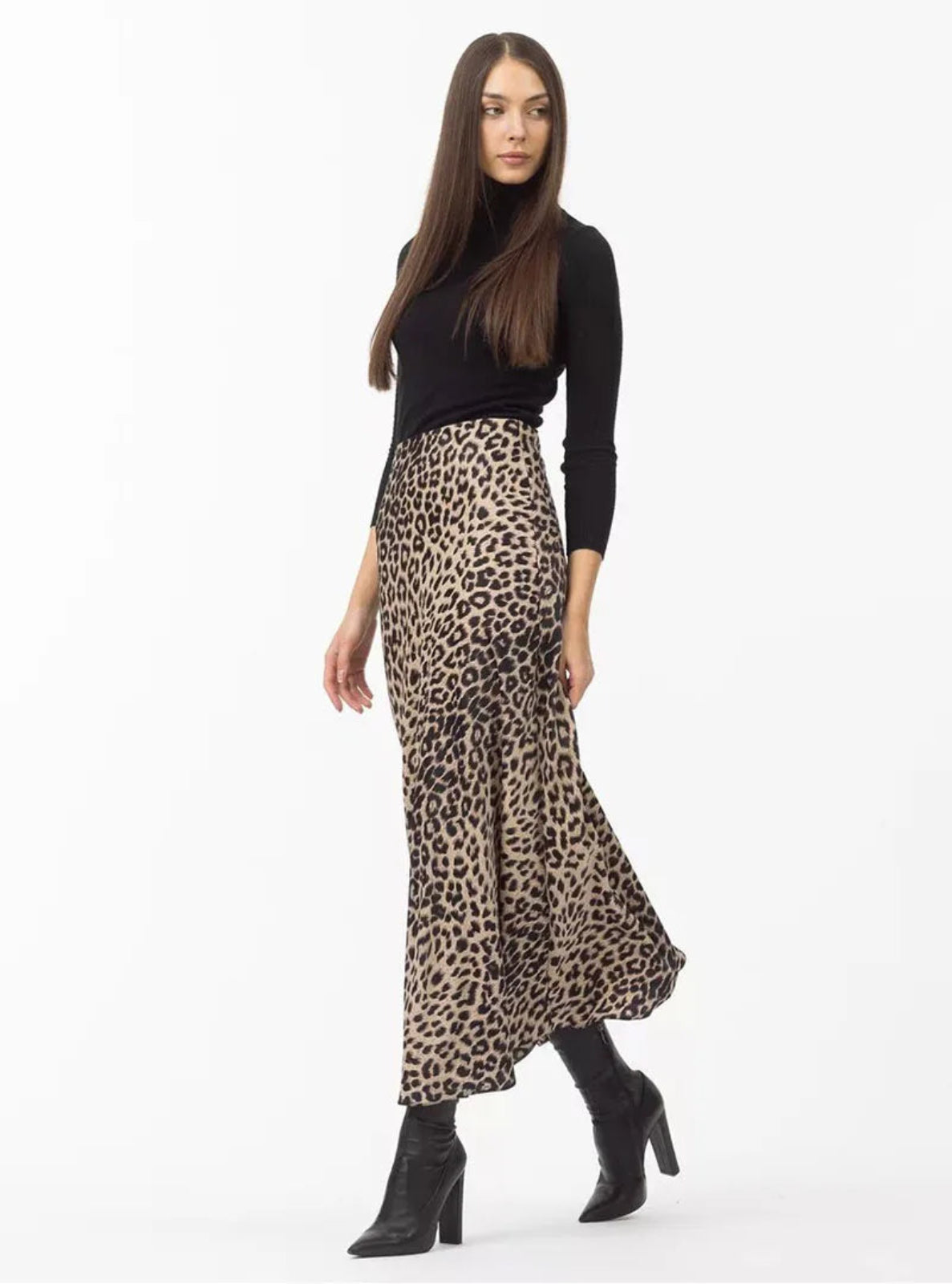 Woman wearing a leopard print skirt and black top on a white background