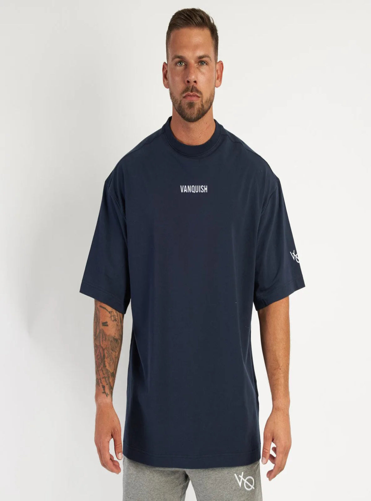 Man wearing a navy blue 'Vanquish' t-shirt on a white background