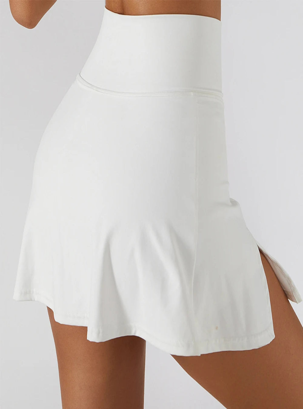White tennis skirt worn by a person on a plain background