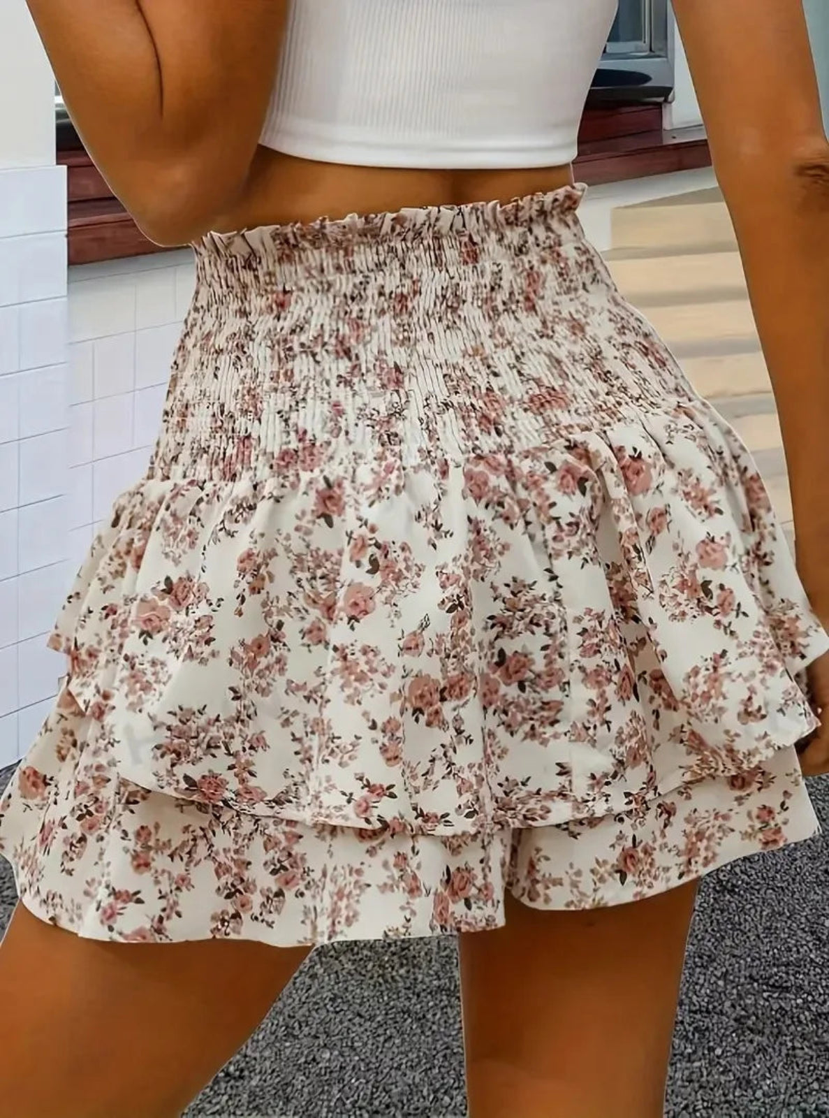 Floral tiered shorts worn by a person in an indoor setting