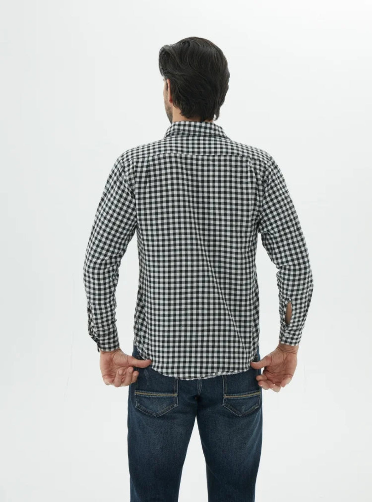 Man wearing a black and white checkered shirt and blue jeans on a white background