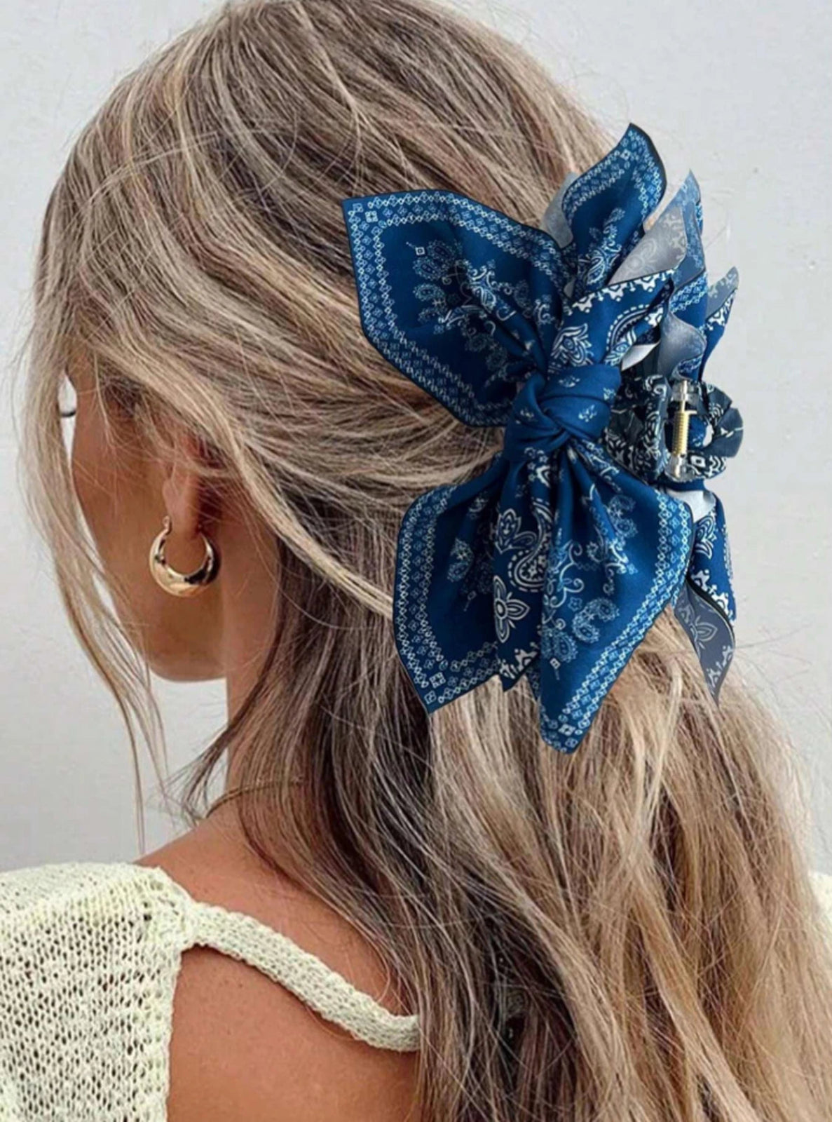 Woman with blue hair bow accessory on a plain background