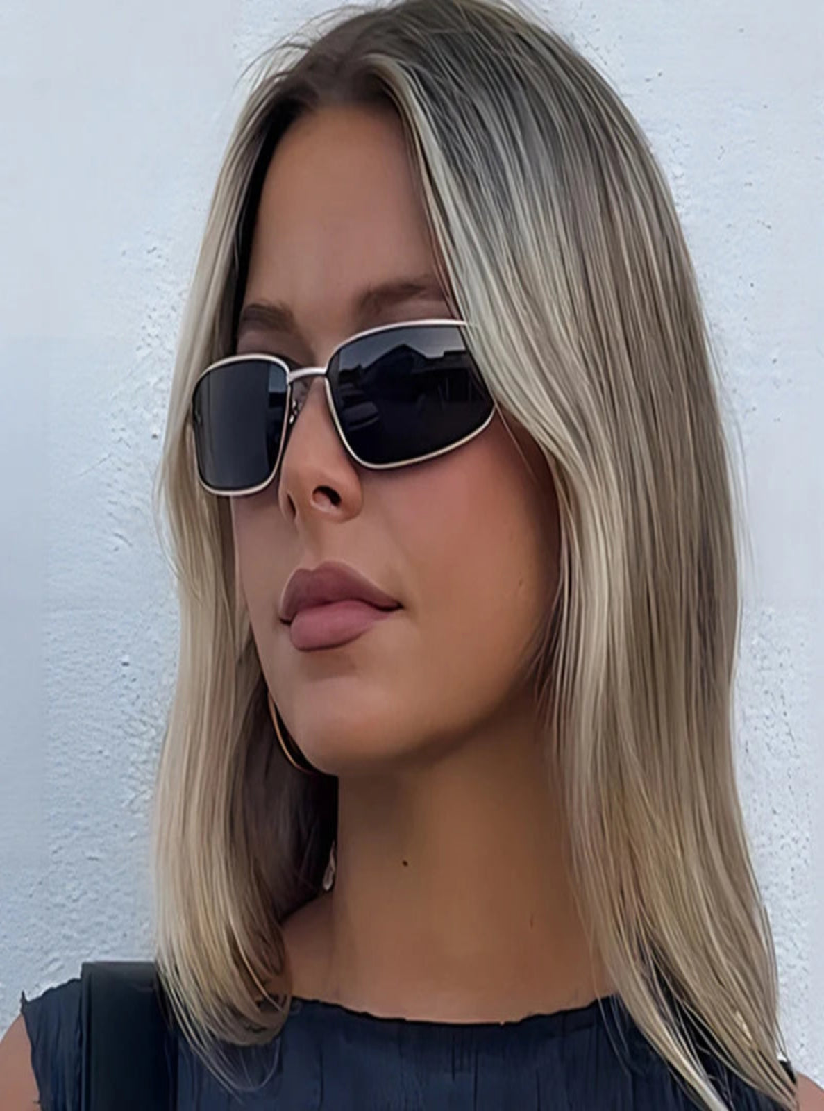 Woman wearing sunglasses with a plain white background