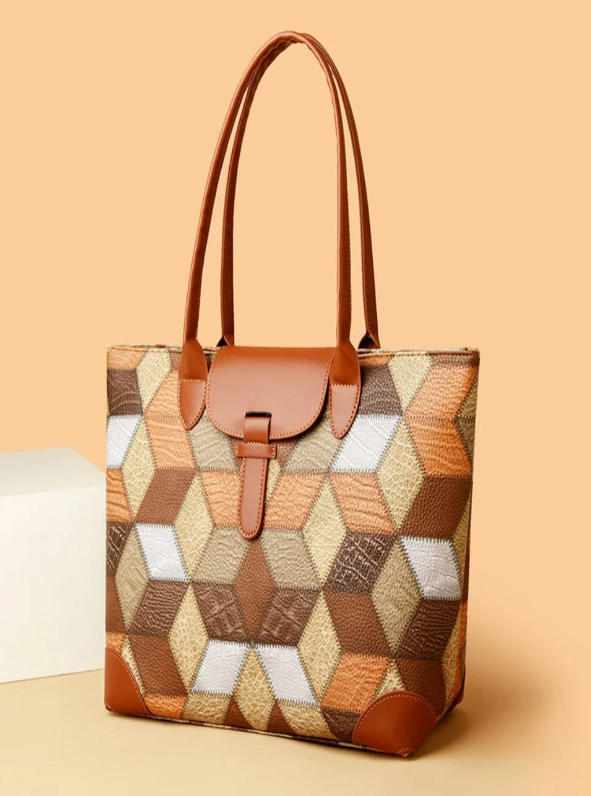 Patterned handbag with brown accents on a beige background