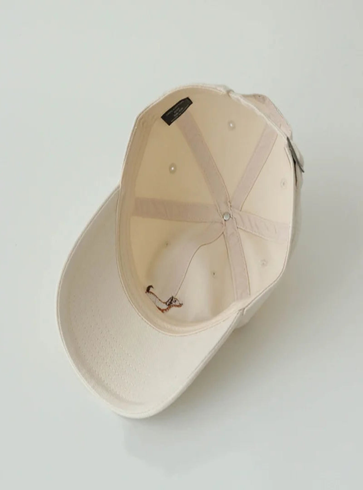Cream baseball cap on a light gray background