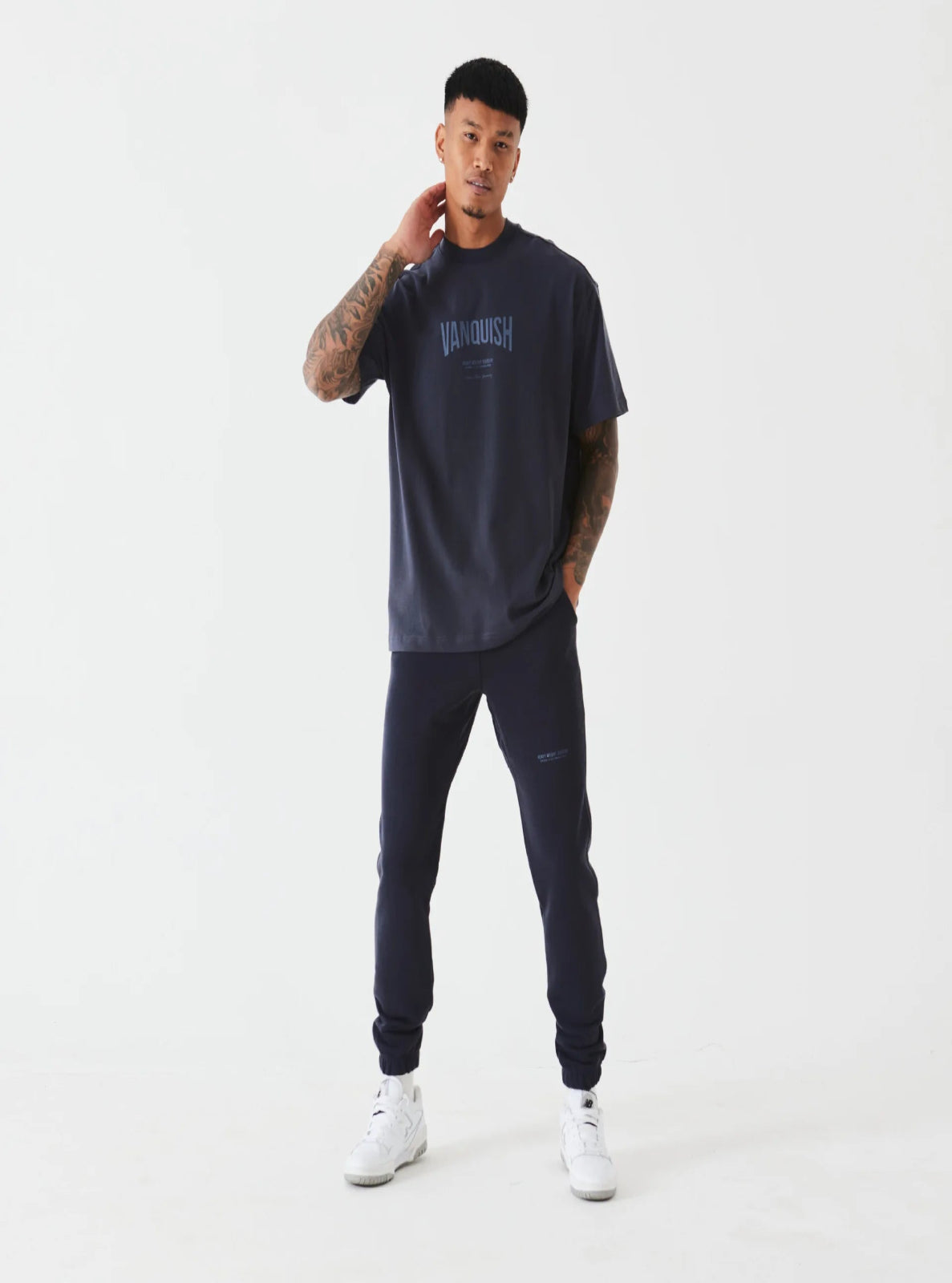 Man wearing a navy tracksuit with 'Vandour' branding on a white background