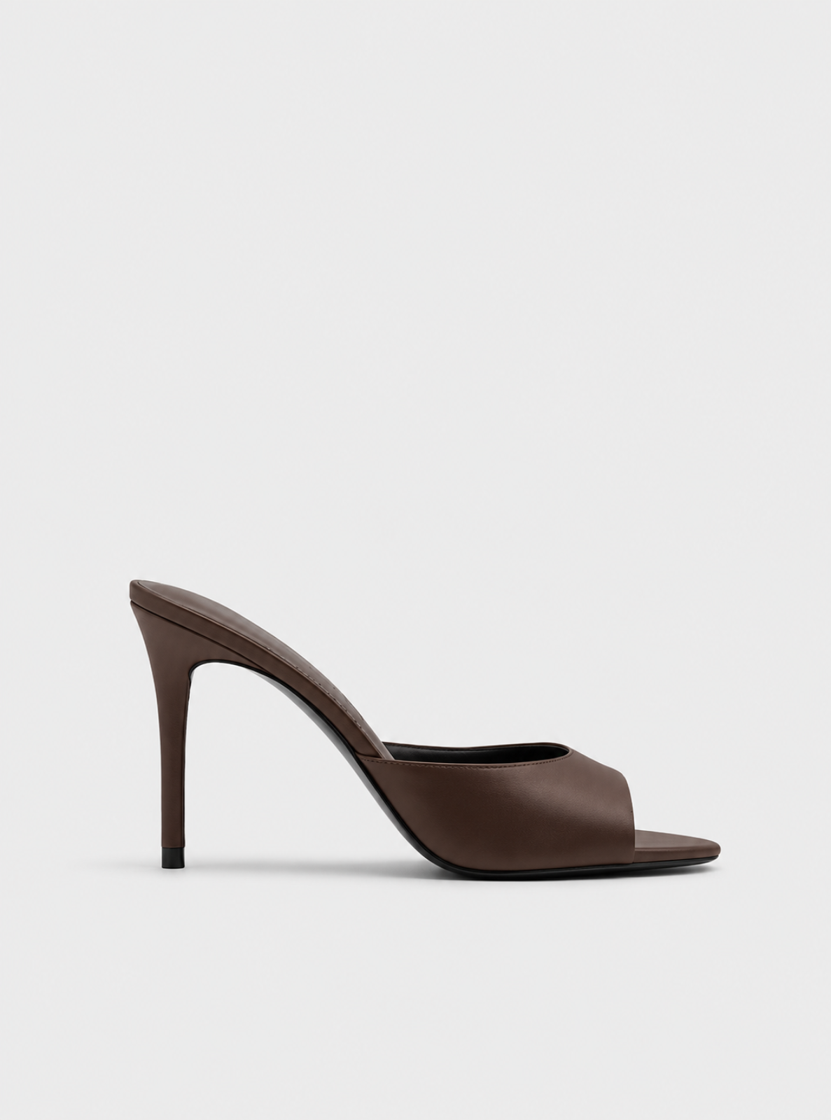 A single dark brown leather high-heeled mule sandal with a slim stiletto heel and open toe, shown from a side profile on a light gray background.