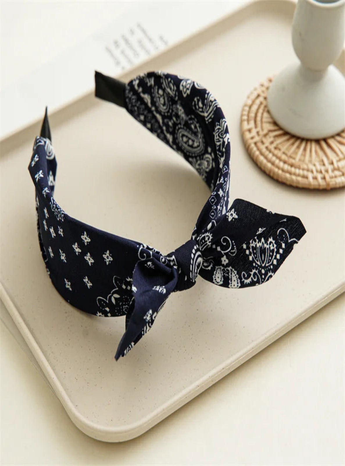 Navy blue headband with white patterns on a beige tray