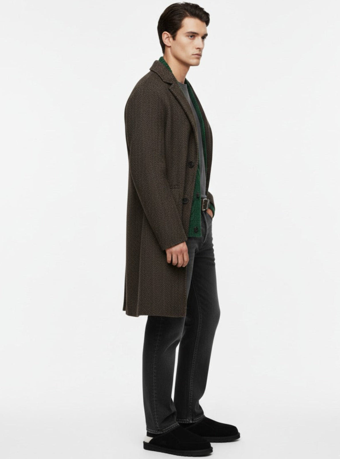 Man wearing a brown overcoat and dark pants on a white background