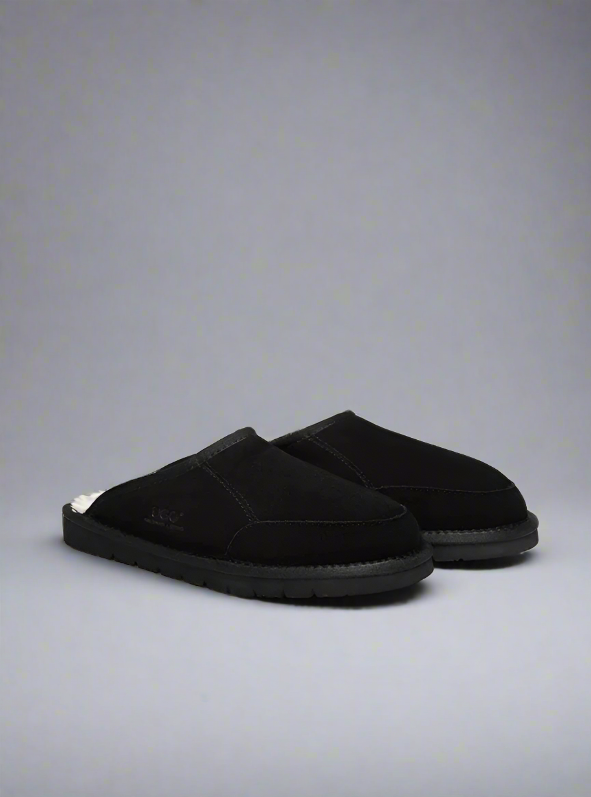 Pair of black slippers on a gray background