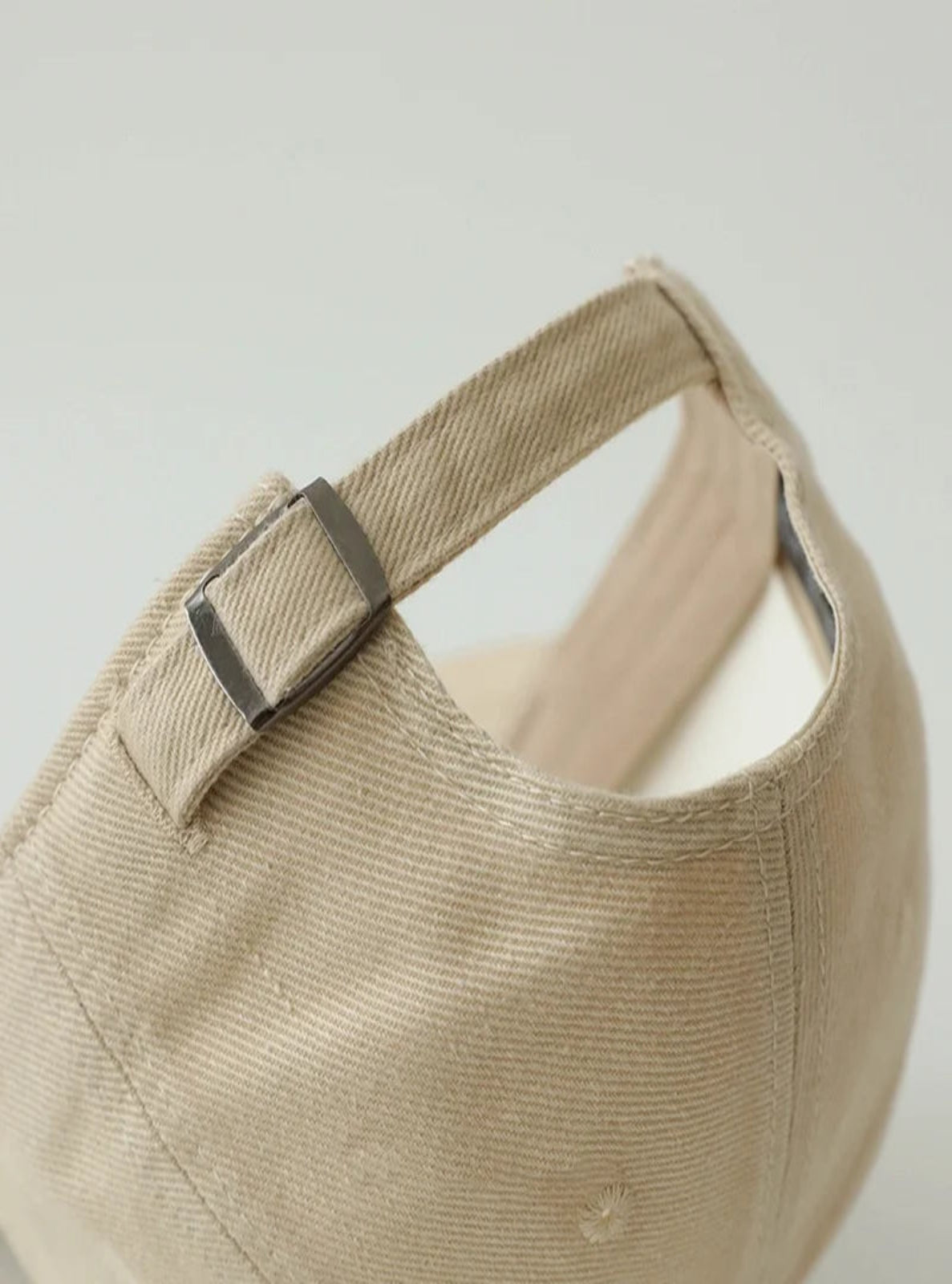 Beige cap with a strap on a light gray background