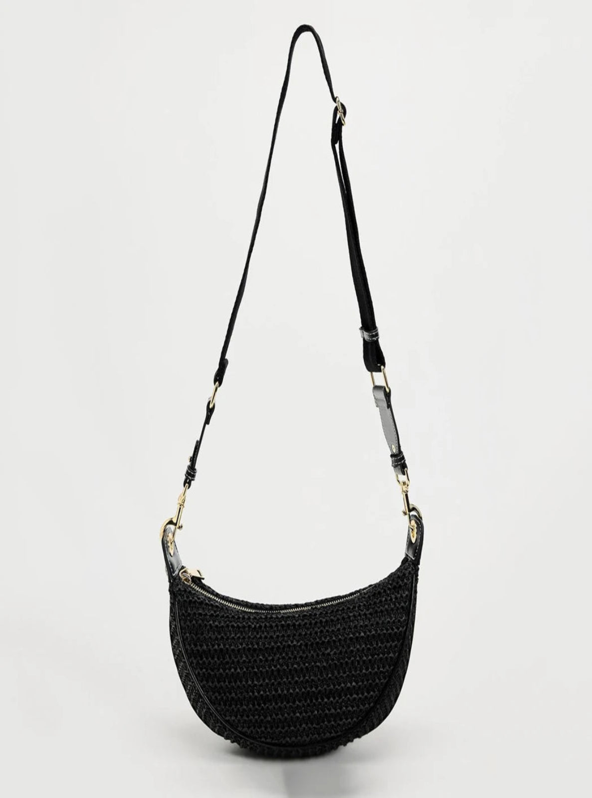 Black woven handbag with a strap on a light gray background