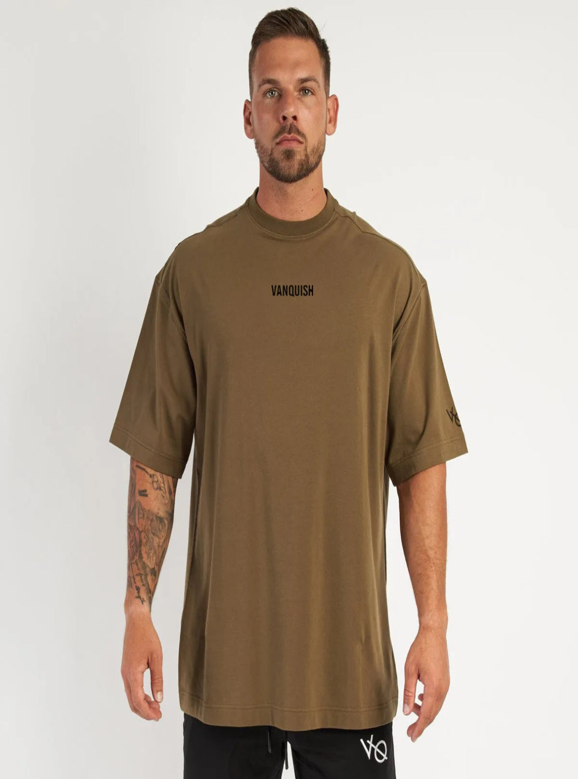Man wearing a brown t-shirt with 'Vanquish' logo on a white background