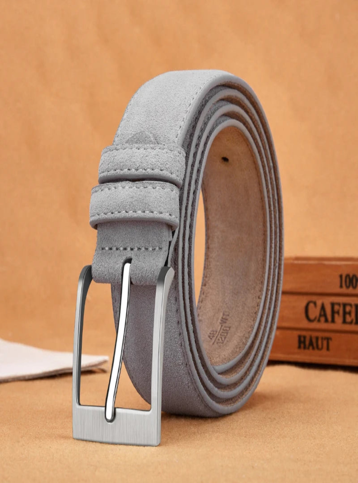 Gray belt with a silver buckle on a beige background
