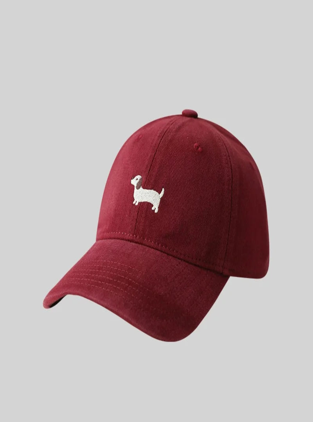 Dark red cap with a small white dog illustration on a gray background