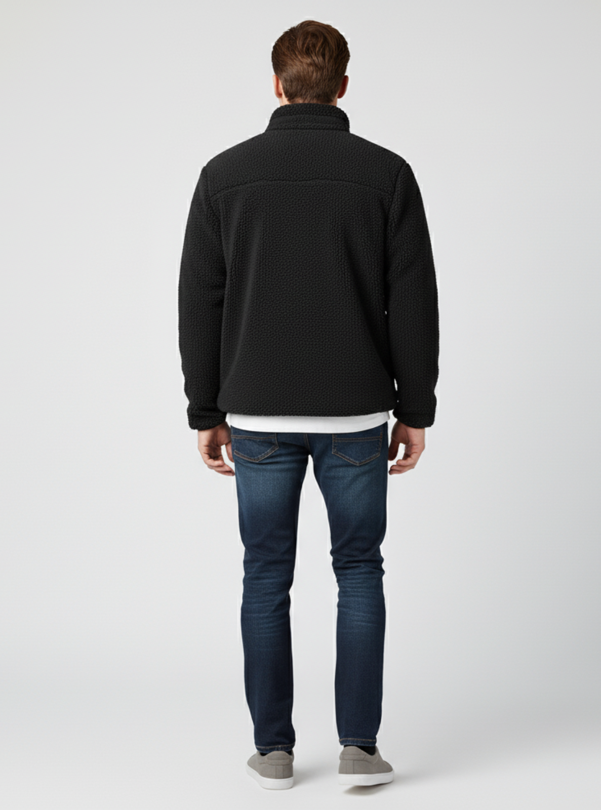 Man wearing a black jacket and blue jeans on a white background