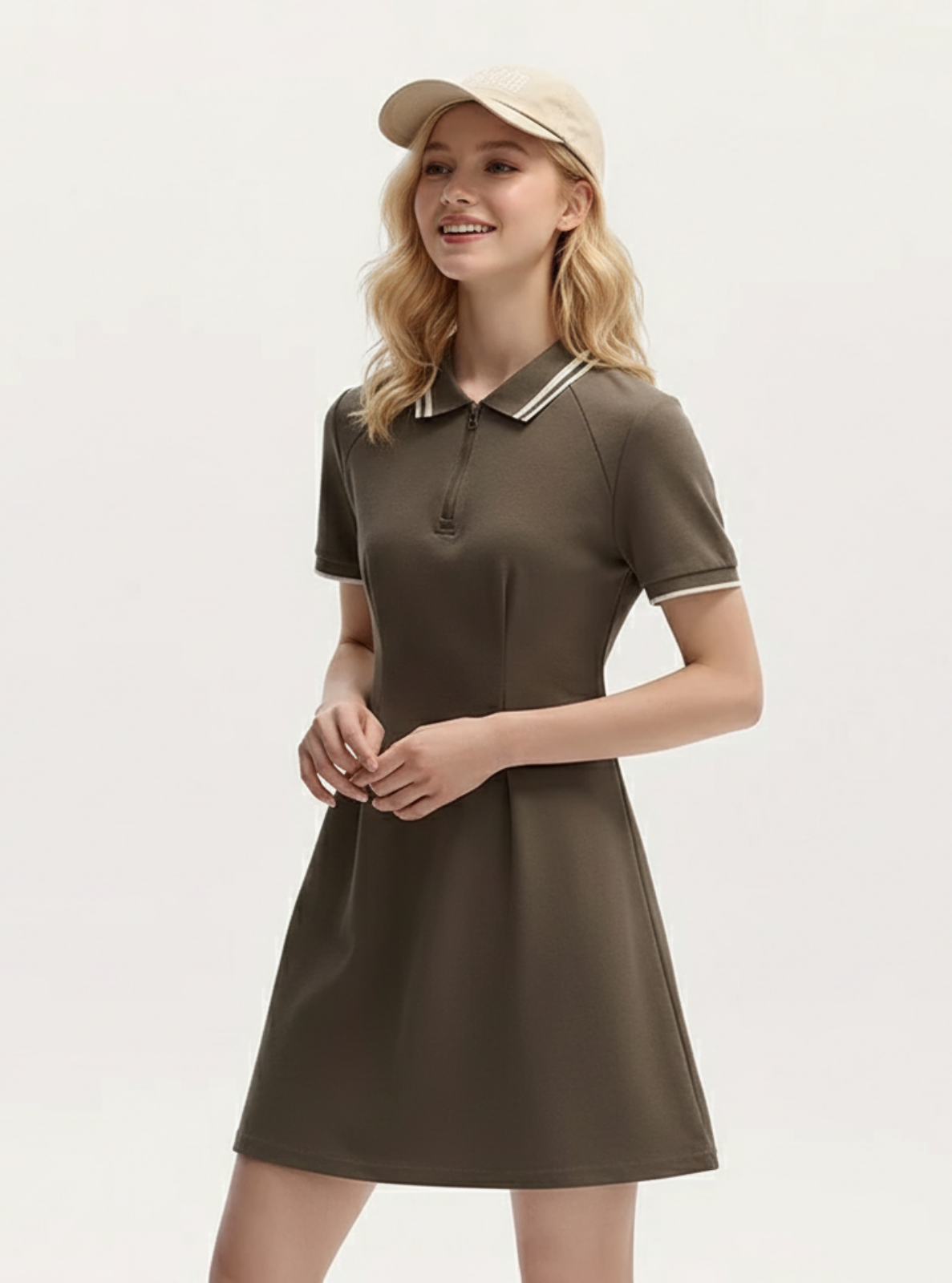 Woman wearing a brown dress with a white collar and a beige cap on a light gray background