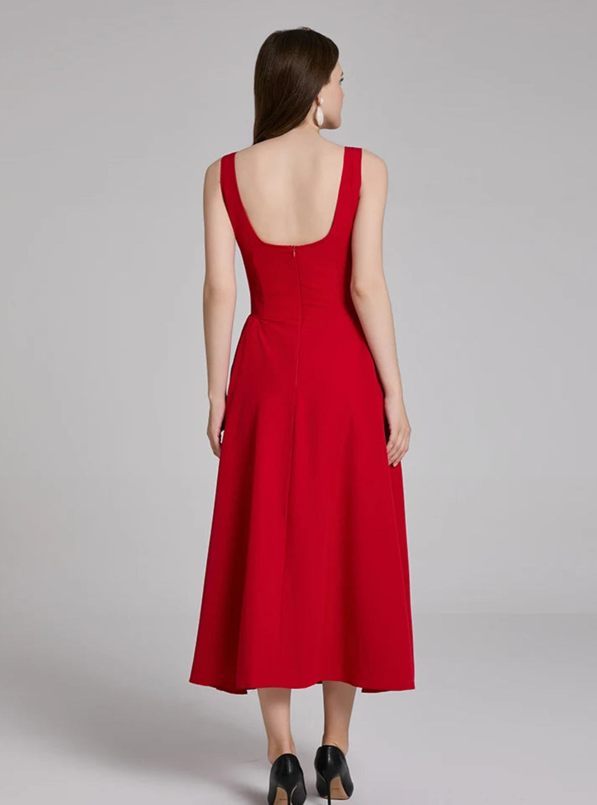 Woman wearing a red dress on a gray background