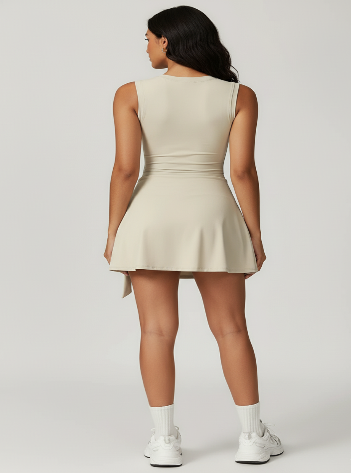 Woman wearing a beige dress on a light gray background