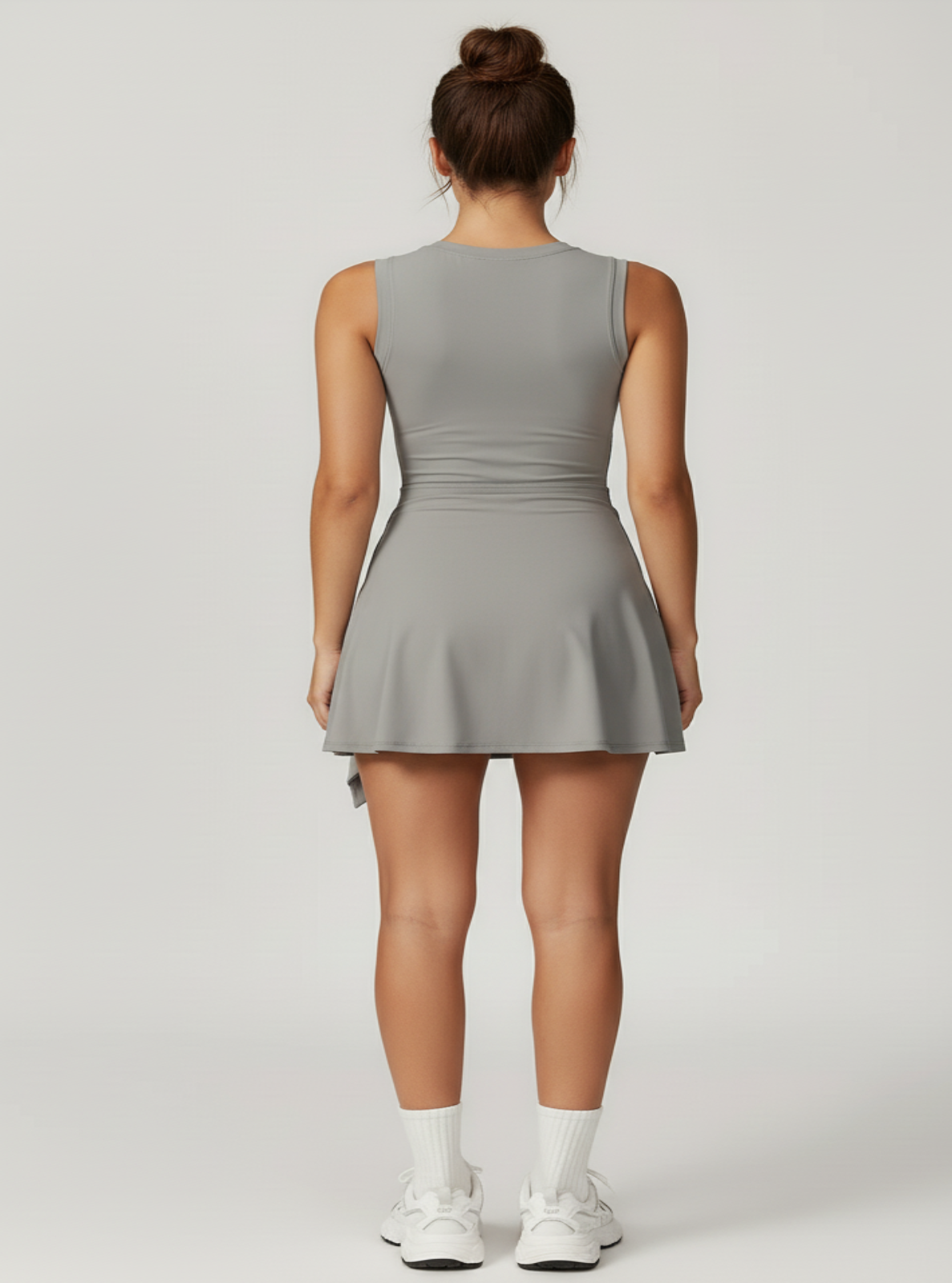 Woman wearing a gray sleeveless dress on a white background