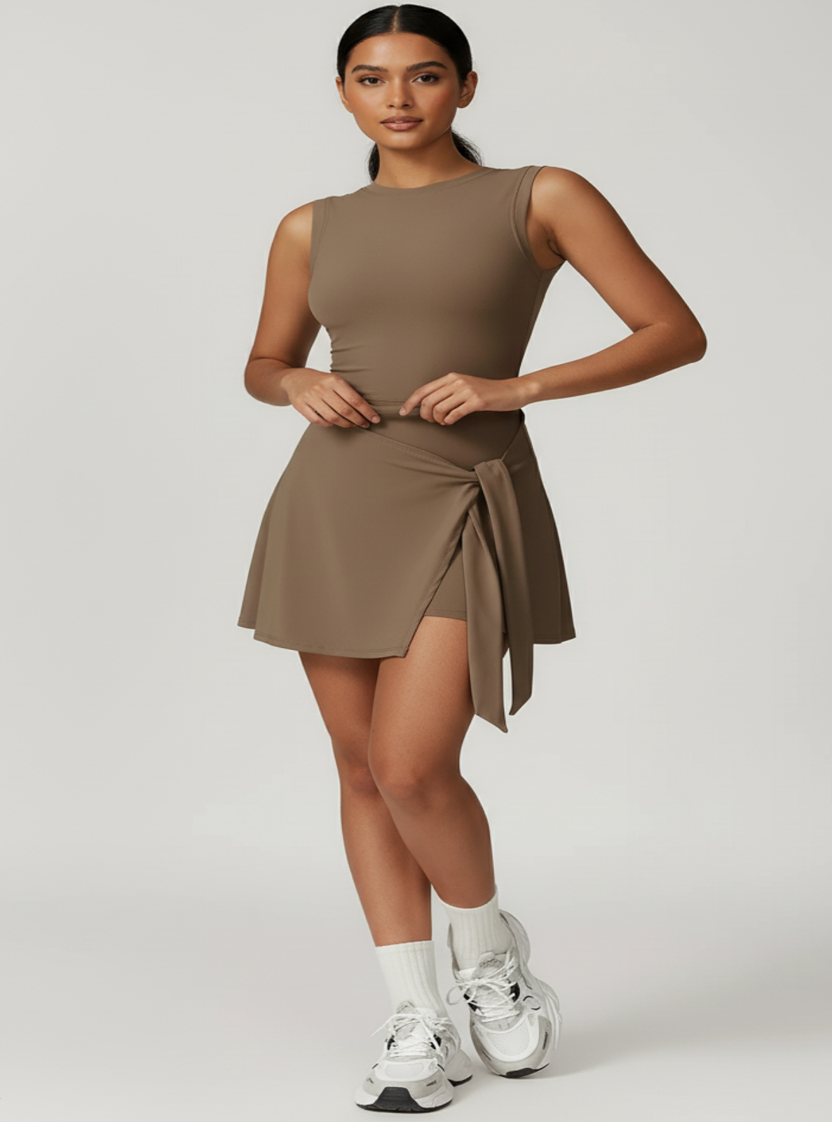 Woman wearing a brown dress with silver shoes on a white background