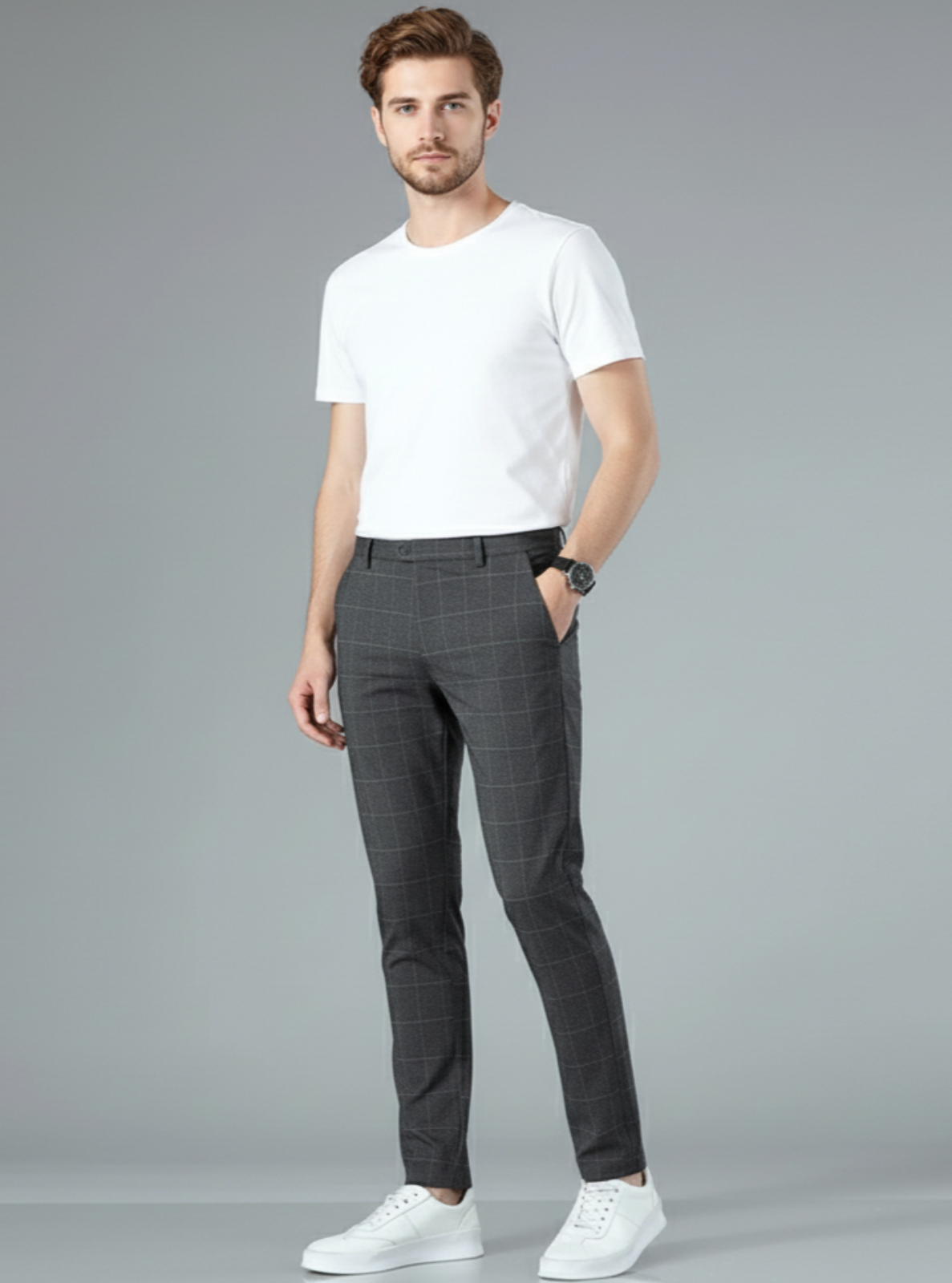 Man wearing a white t-shirt and gray checkered pants on a gray background