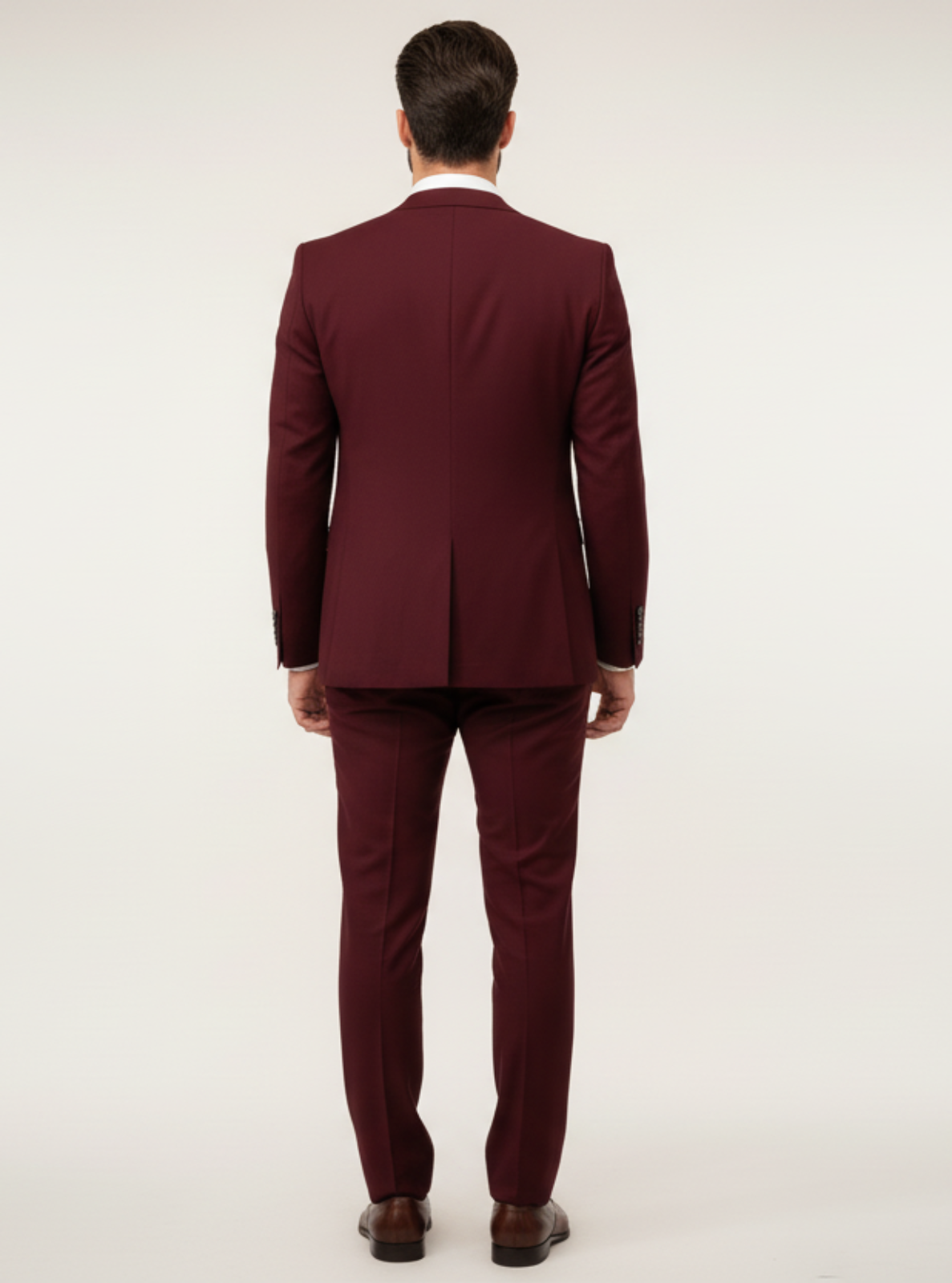Man wearing a burgundy suit on a white background