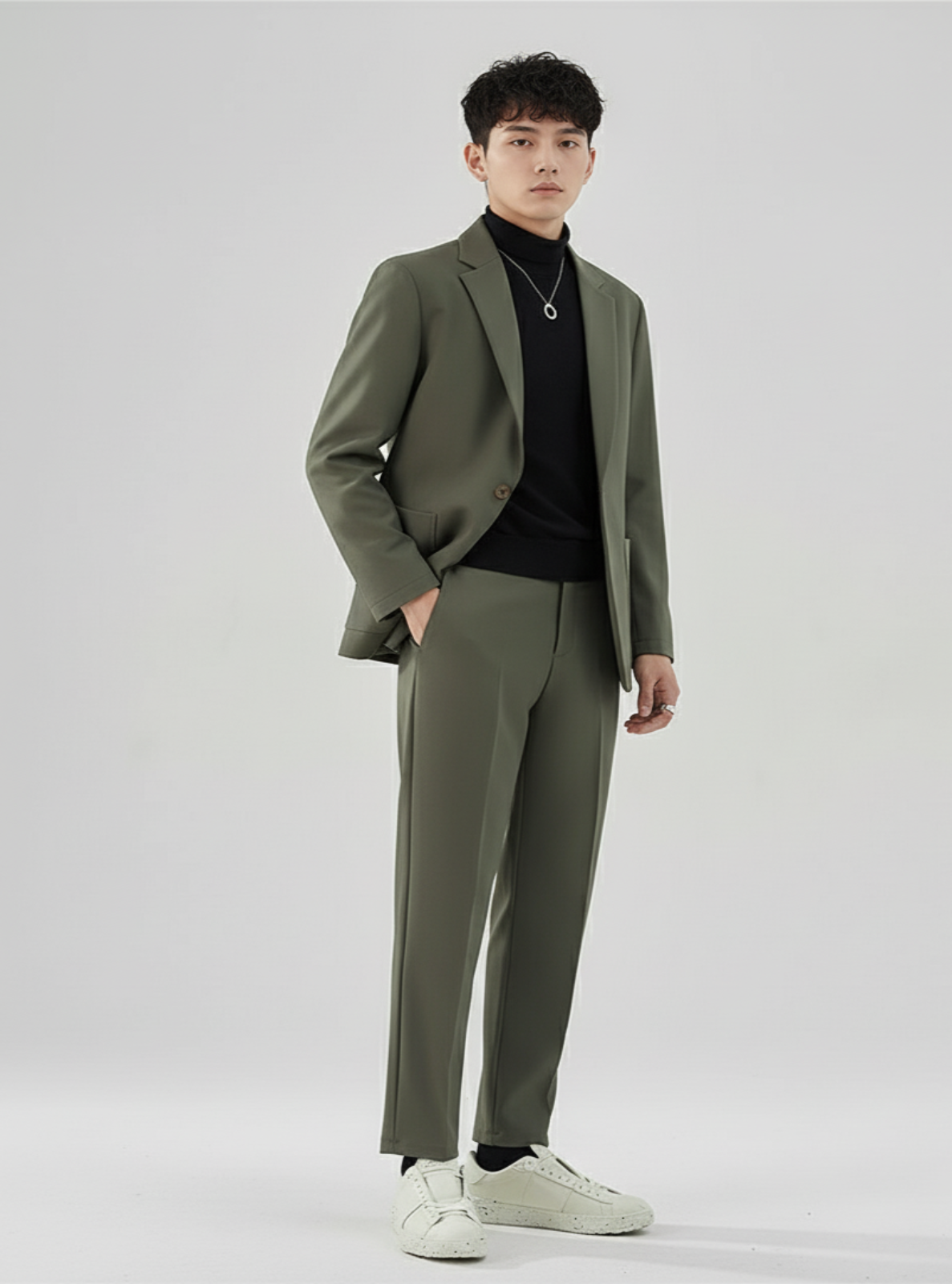 Man wearing a green suit with a black shirt on a white background