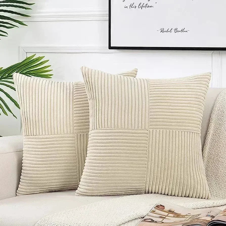 Beige textured pillows on a sofa with a plant and framed quote in the background.