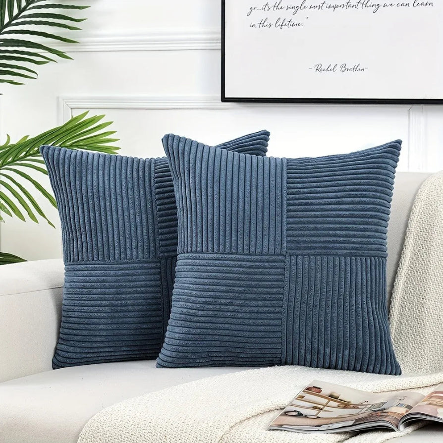 Two blue textured pillows on a sofa with a framed quote in the background.