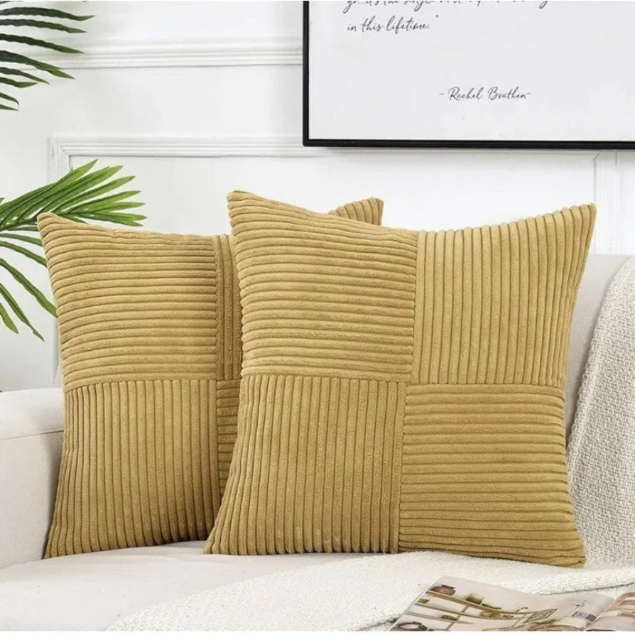 Two mustard yellow textured pillows on a white sofa with a framed quote in the background.