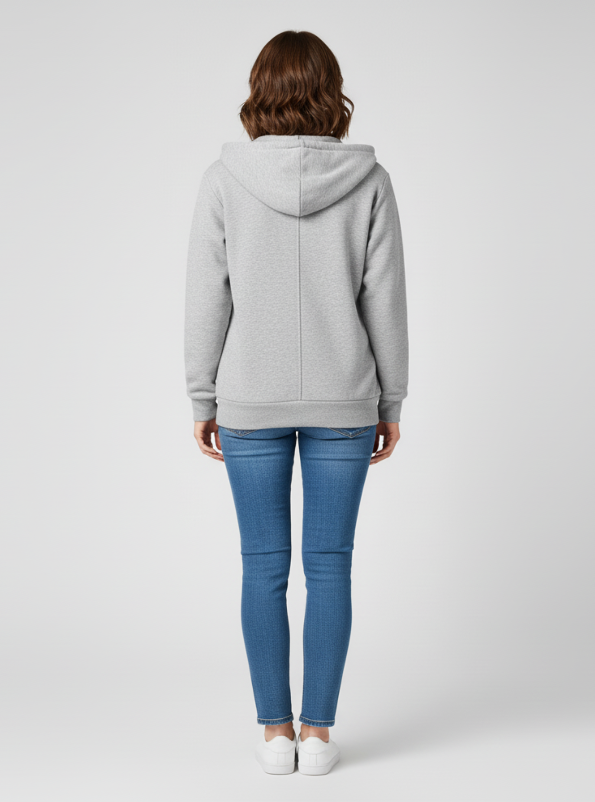 Person wearing a gray hoodie and blue jeans on a white background
