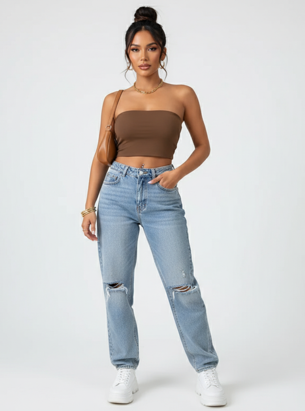 Woman wearing a brown strapless top and light blue jeans on a white background