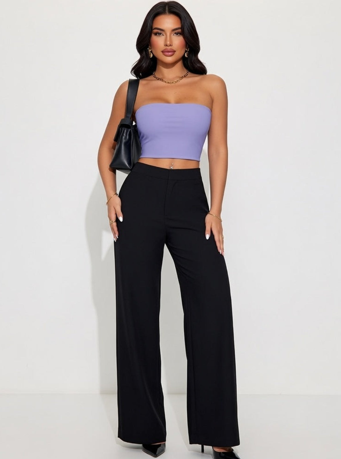 Woman wearing a purple strapless top and black high-waisted pants against a white background