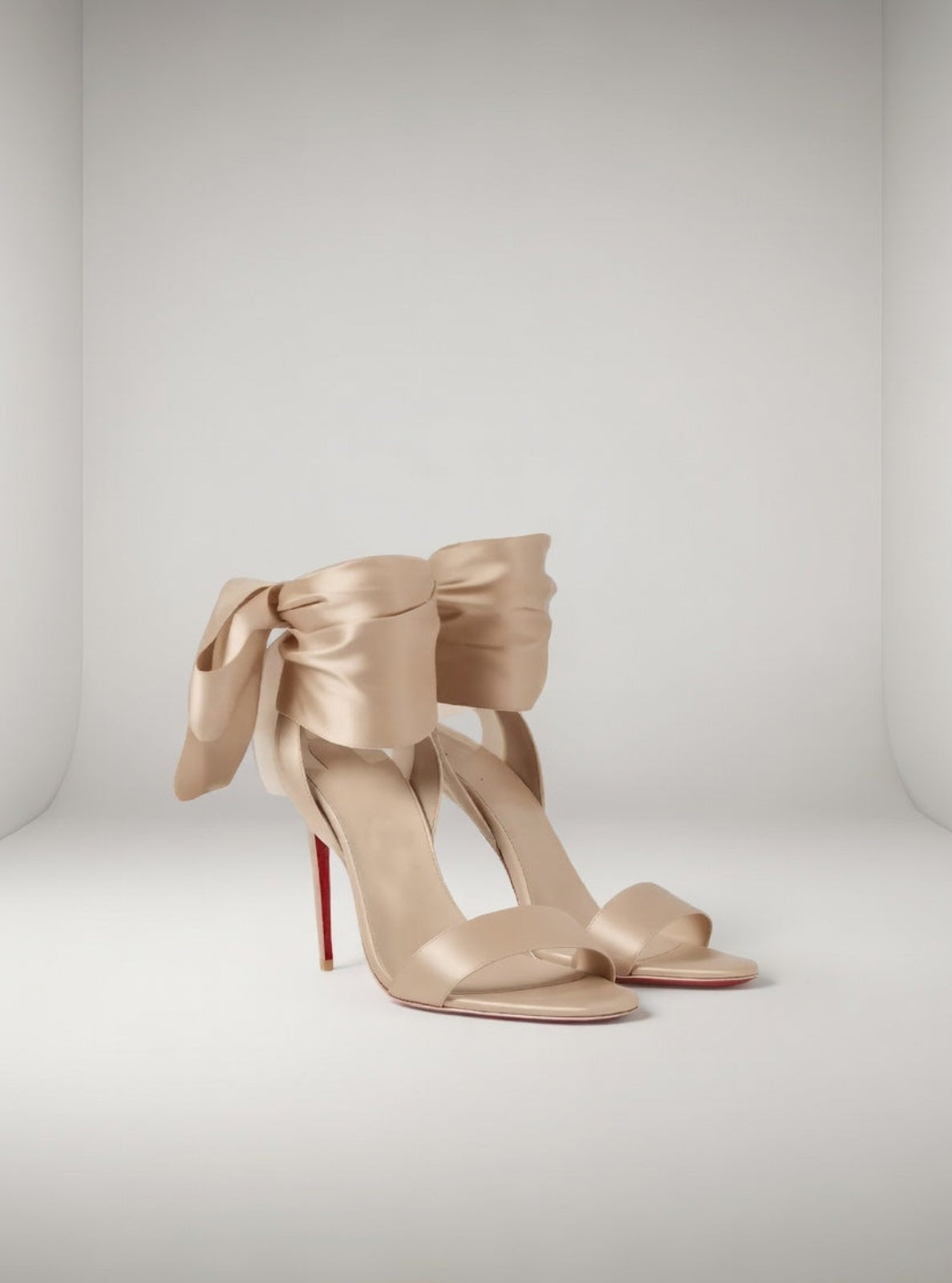 Beige high-heeled shoes with large bows on a white background