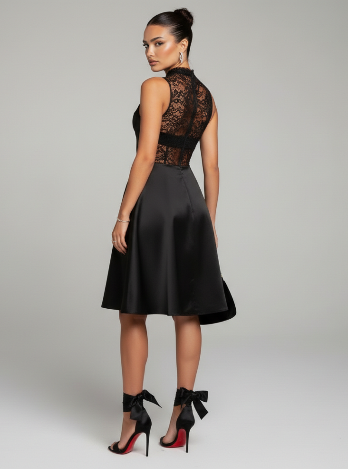 Woman wearing a black lace top and skirt set on a gray background