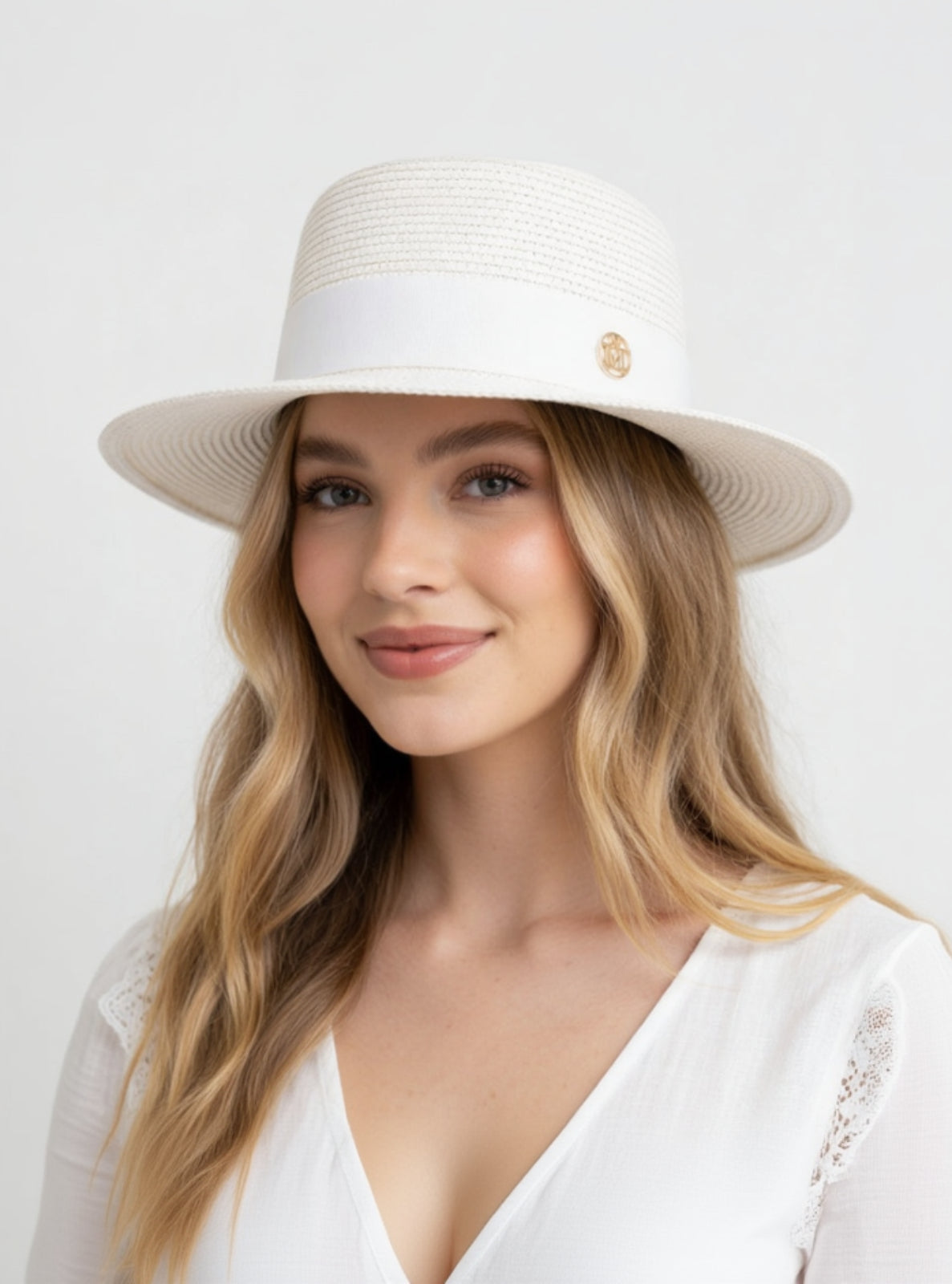 Woman wearing a white sun hat on a plain background