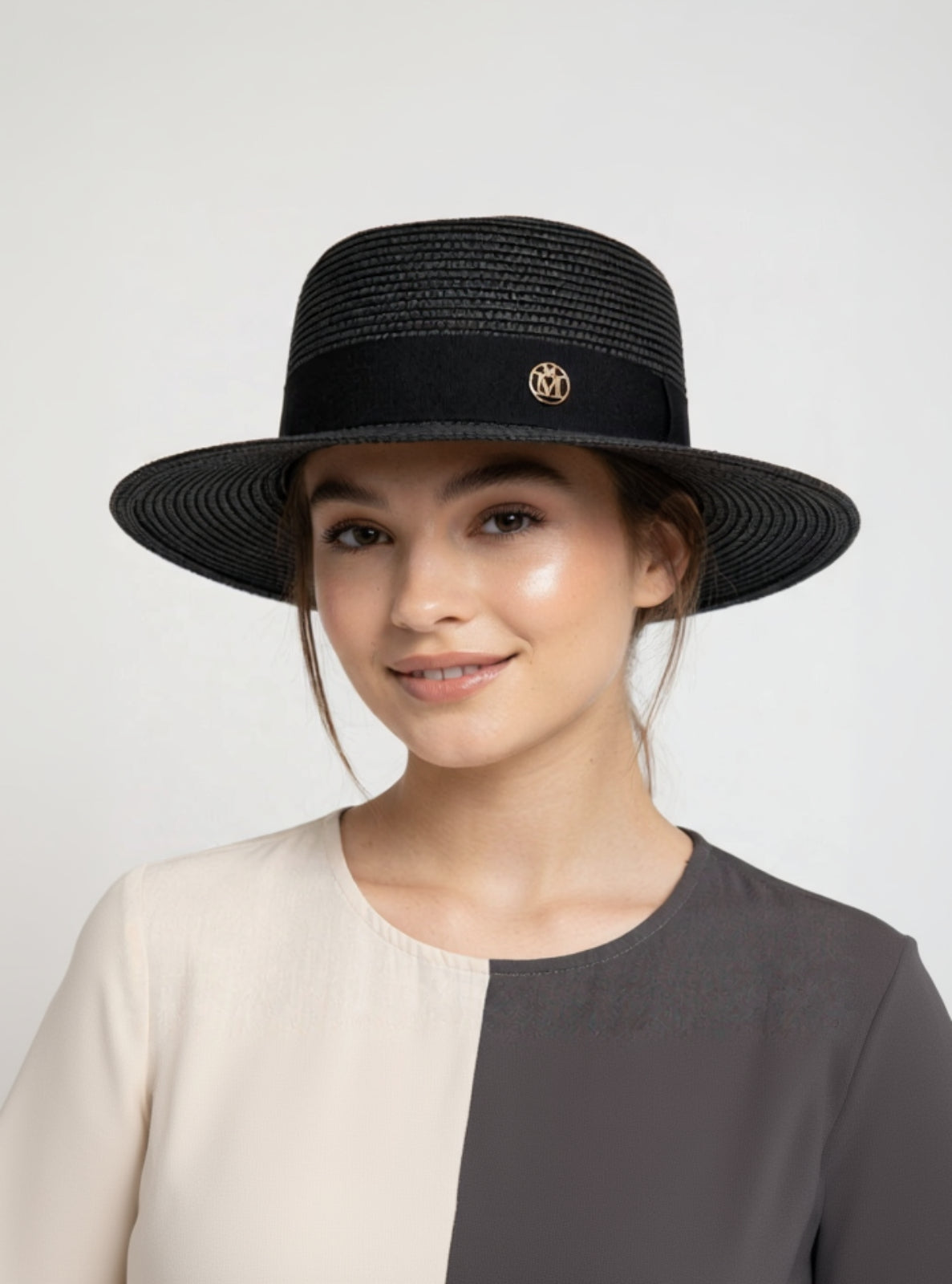 Woman wearing a black straw hat with a logo on a white background